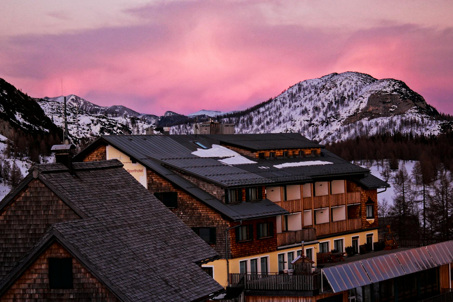 Weekend w polskich górach zimą – najlepsze hotele z widokiem i trasy na krótki wypad Górski pensjonat o zmierzchu, w śniegu i różowym zimowym niebie