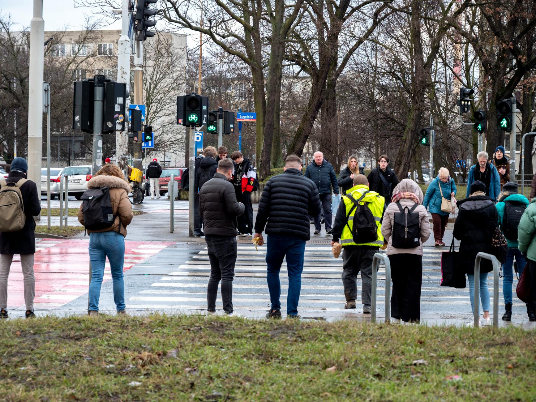 Piesi przechodzący przez skrzyżowanie w dużym mieście w pochmurny dzień