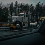 Ciężarówka z ładunkiem ponadgabarytowym na mokrej autostradzie